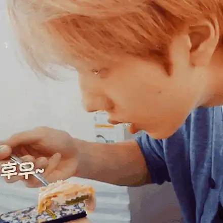Someone leaning over a plate to blow on a forkful of food that is clearly still too hot to eat